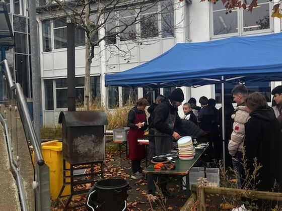 Eine Gruppe von Schülern steht unter einem Pavillon