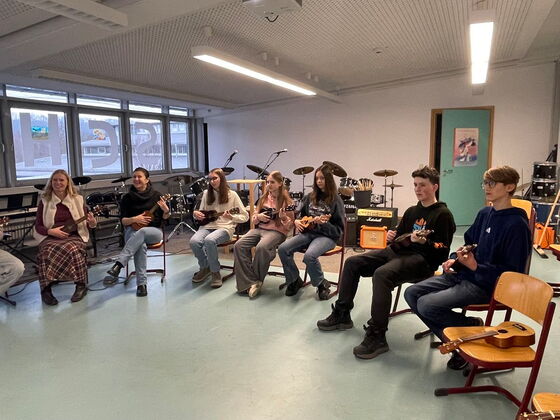 Eine Gruppe von Schülern sitzt mit Instrumenten im Stuhlkreis