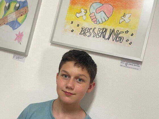 Schüler Daniel vor seinem Gemälde "Gute Besserung"